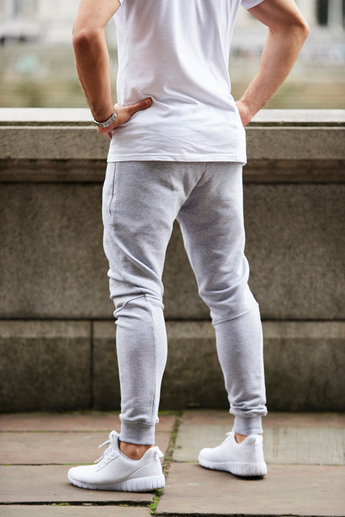 Back angle view of man on path wearing a pair of fitted light grey marl gym joggers