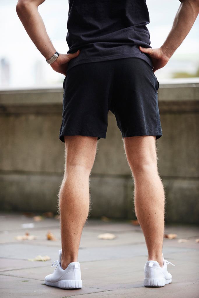 Back shot of man wearing black workout shorts on the street