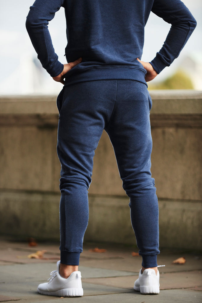 Back view of athlete wearing a pair of Sole Ambition navy workout pants with zips, in the streets of London