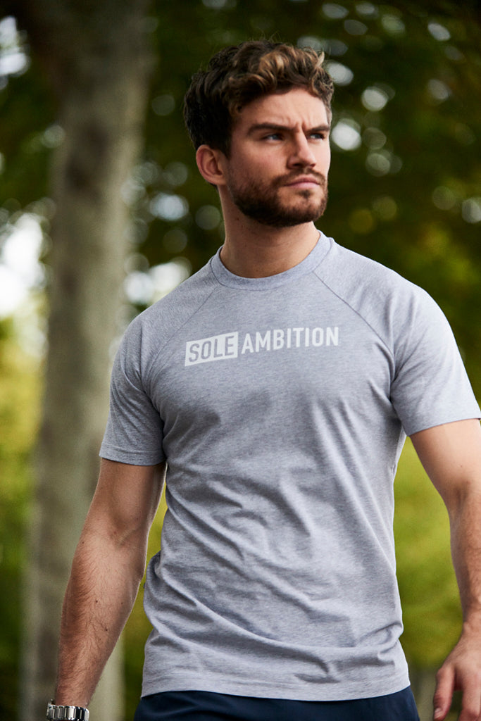 Close up of man walking in London with a slim fitting mens grey gym t-shirt on from Sole Ambition