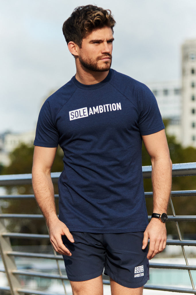 man walking on a London bridge wearing a slim fitting navy cotton gym tee from Sole Ambition