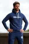 Man standing in a power pose wearing a navy mens workout hoodie in a slim fit cut.