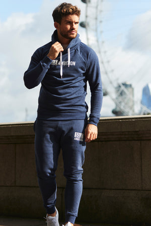 Athlete posing in navy blue marl gym tracksuit bottoms and hoodie with London eye in the background