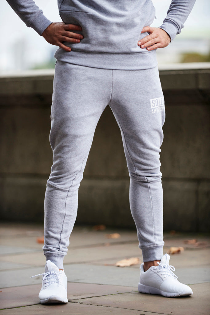 Front shot of man wearing a pair of Sole Ambition skinny grey men's gym joggers with zip pockets