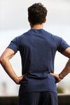 Back view of a man power posing with a navy Sole Ambition top on