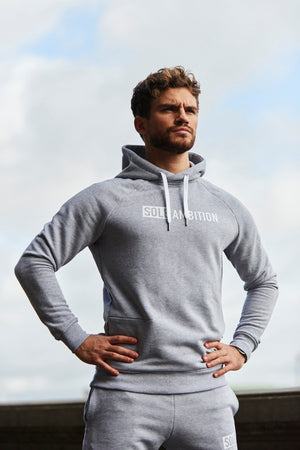 Man standing tall wearing a grey cotton gym training hoodie 